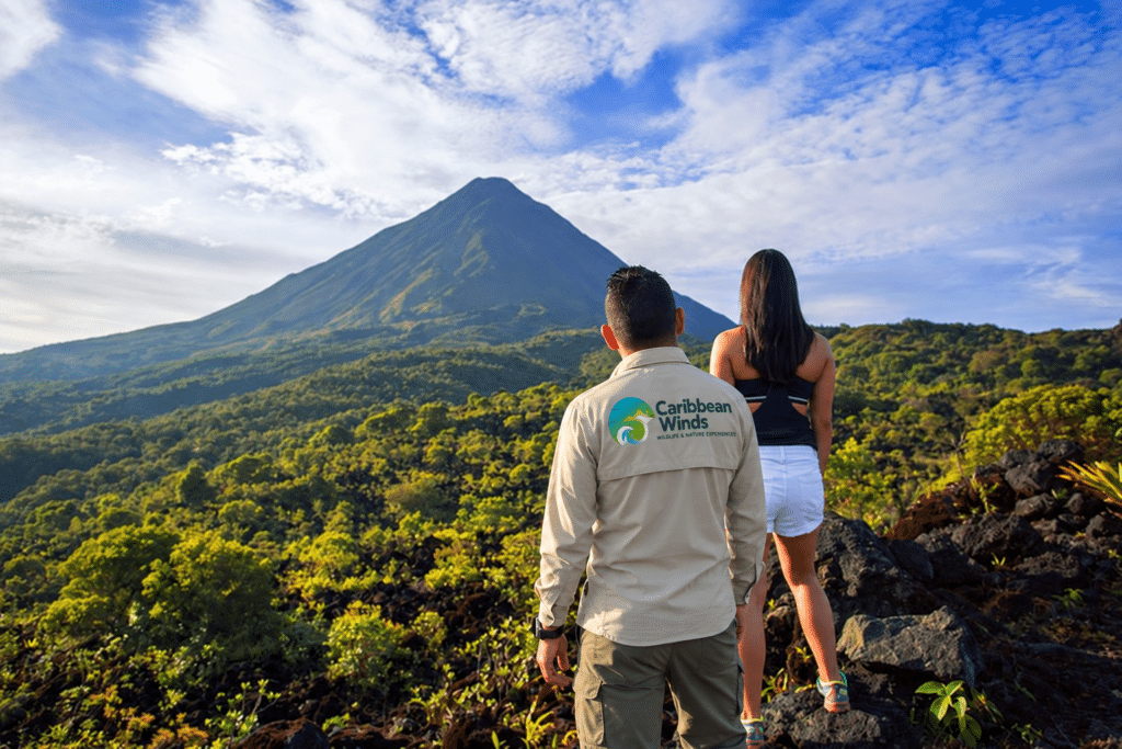 Arenal Volcano viewed from Reserva El Silencio, with a guide wearing a Caribbean Winds shirt — edited promotional image
